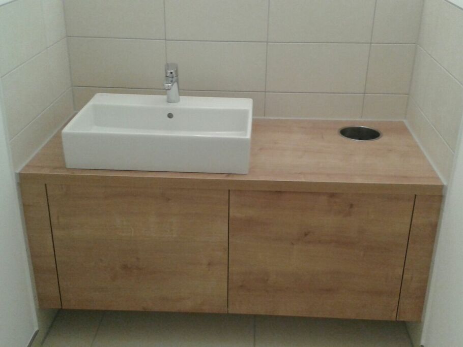 Weißes Waschbecken auf Badschrank aus hellem Holz