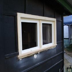 Zweiteiliges Fenster nach Maß in schwarzer Hauswand