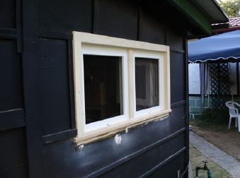 Zweiteiliges Fenster nach Maß in schwarzer Hauswand