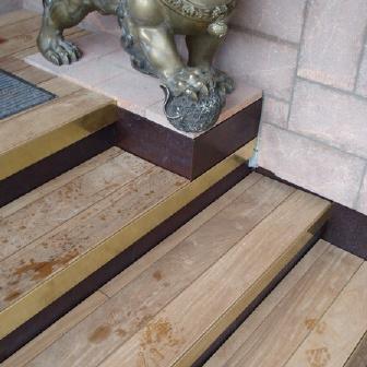 Eine Treppe nach Maß mit einzigartigem Muster auf hellen Holzstufen, neben einer asiatischen Löwenstatue.