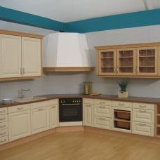 Elegante Küche nach Maß mit beige-farbenen Schrankfronten, Holz-Arbeitsplatte und Glas-Hängeschränken.