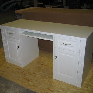 Ein neu gefertigter, weißer Schreibtisch mit klassischem Design und Schubladen, Beispiel für Möbel nach Maß.