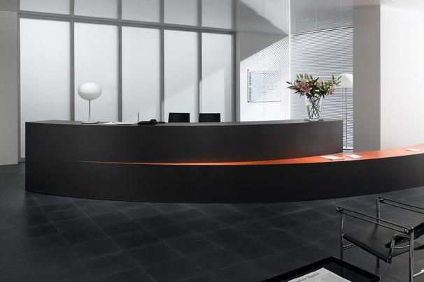 Hotelrezeption mit schwarz lackierter Empfangstheke und orangenem Kontrast