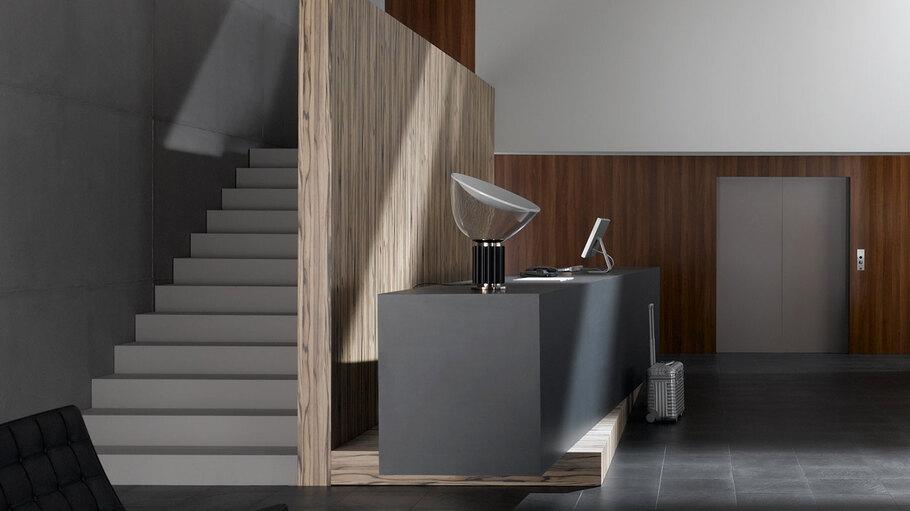 Hotelappartment Untergeschoss mit Holzmobiliar, dunklem Parkett und Treppenaufstieg