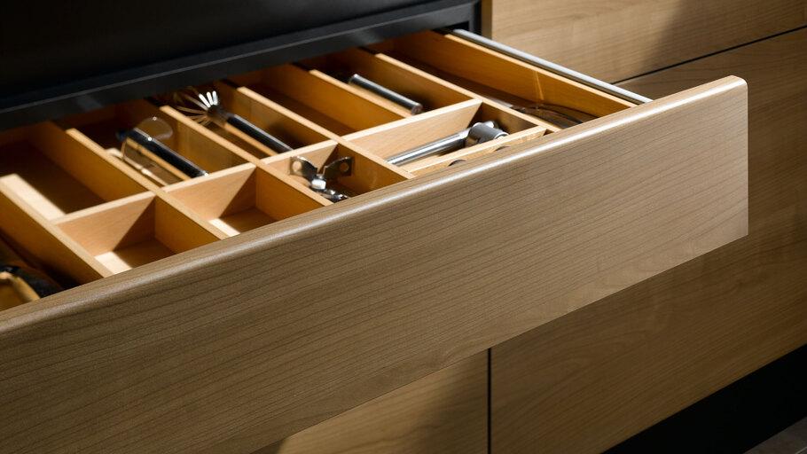 Detailaufnahme einer Besteckschublade aus hellem Massivholz