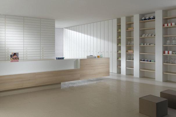 Impressionen einer Apothekeneinrichtung mit hellen Holzmöbeln und geräumigem Regalsystem, sowie aufgeräumten Empfang.