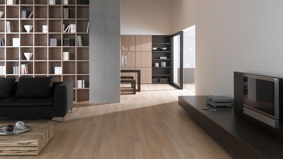 Offene Wohnraumimpression mit Einbauregal für Bücher und Dekoration in Trennwand mit hellem Holzboden