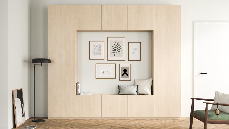Ein maßgefertigter, heller Holzschrank mit eingebauter Sitznische und dekorativen Rahmen an der Wand, harmonisch in einen gemütlichen Wohnbereich integriert.
